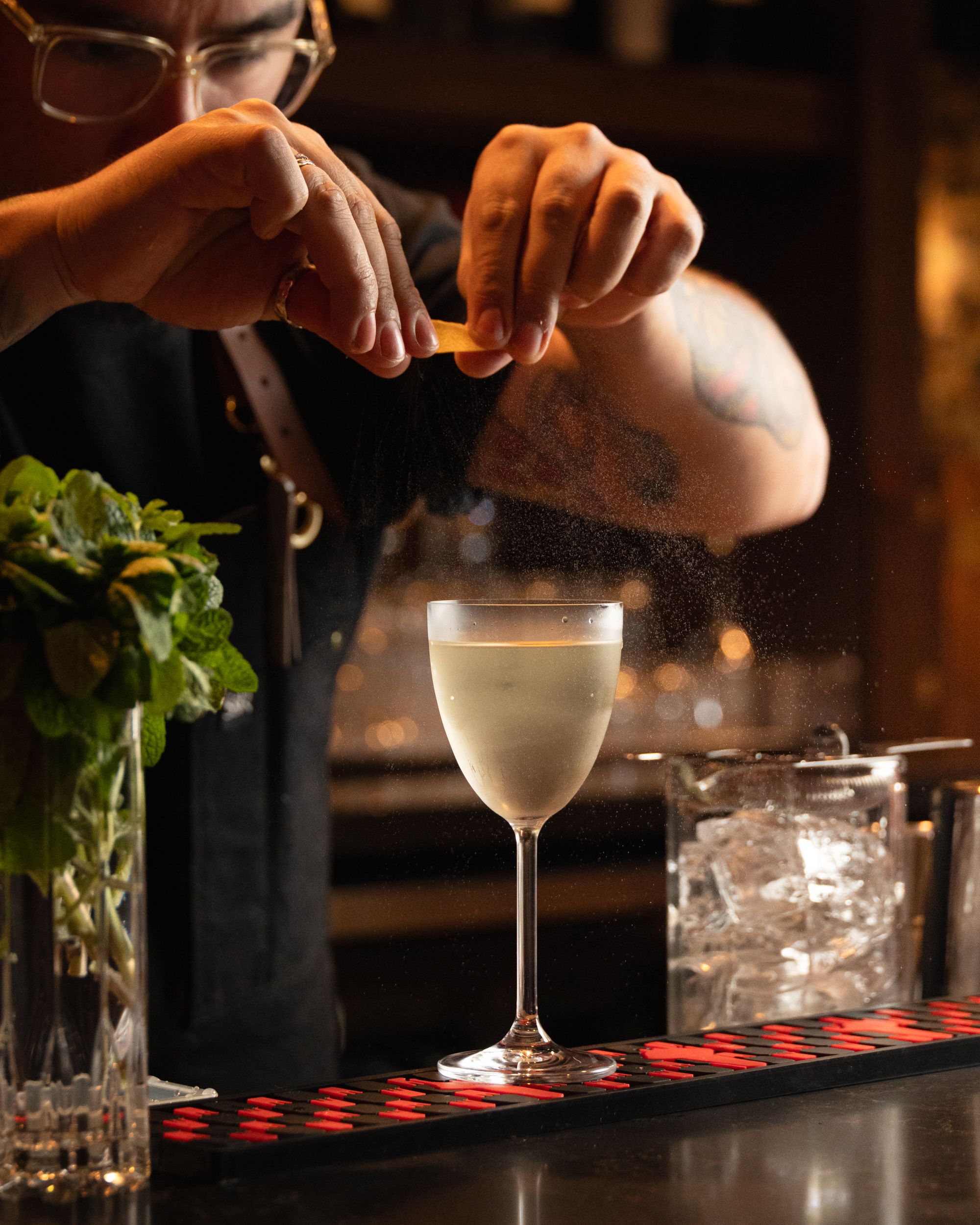 Bartender expressing citrus peel over a pale cocktail at Terminal City Club