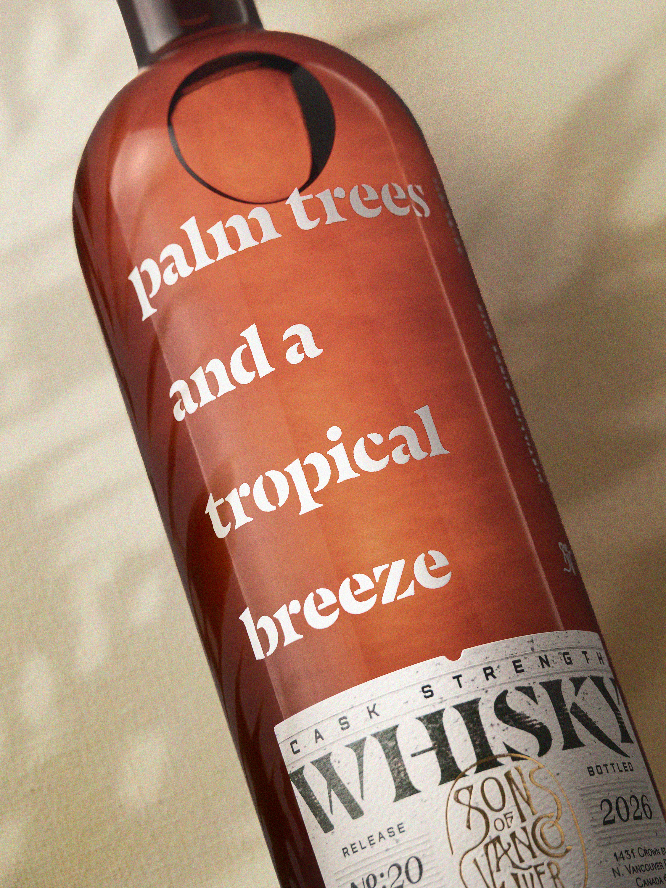 Angled detail of the Palm Trees bottle, backlit to reveal the rum cask colour through dark brown glass