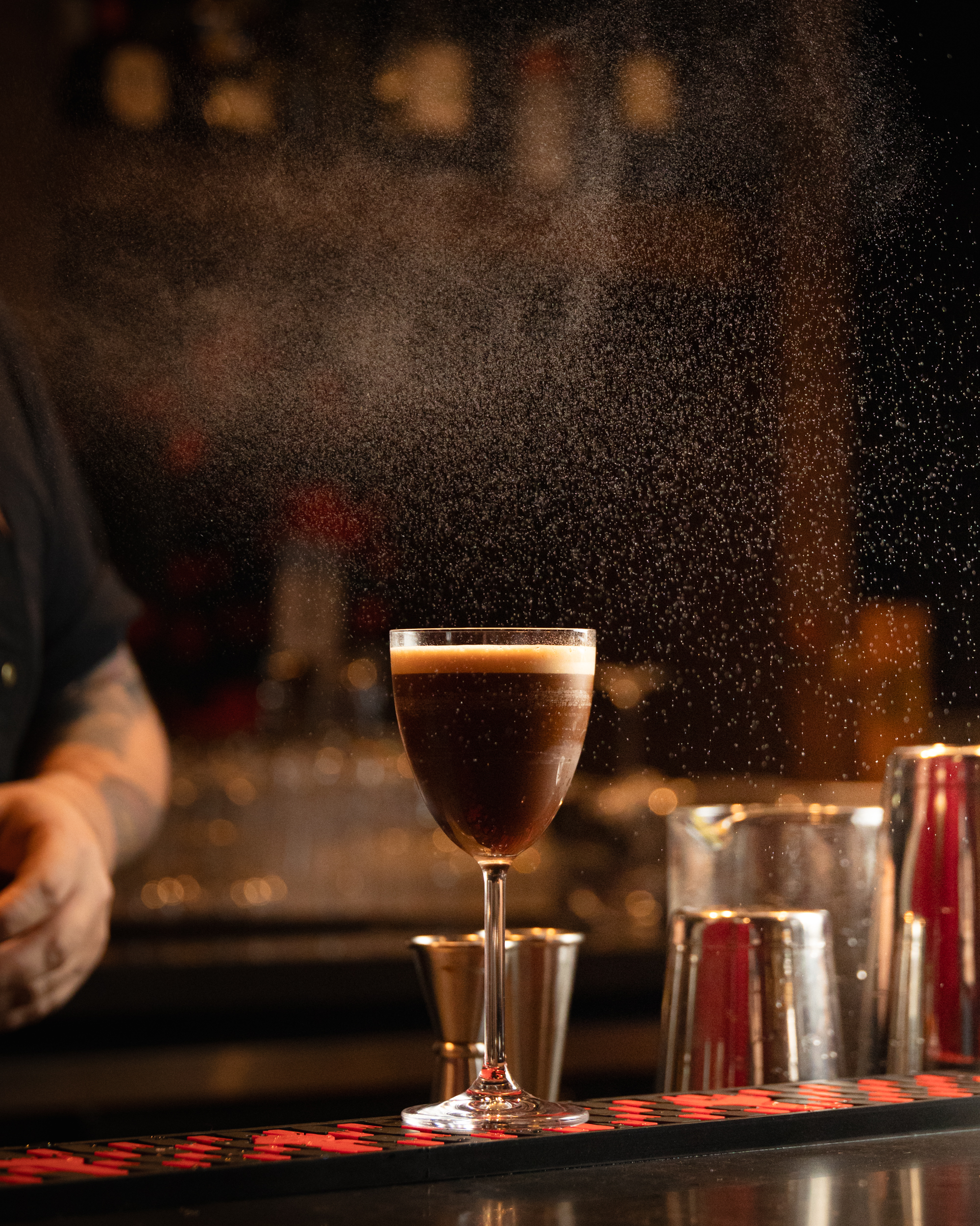 Dark espresso cocktail with a spice mist cloud rising above the glass at Terminal City Club