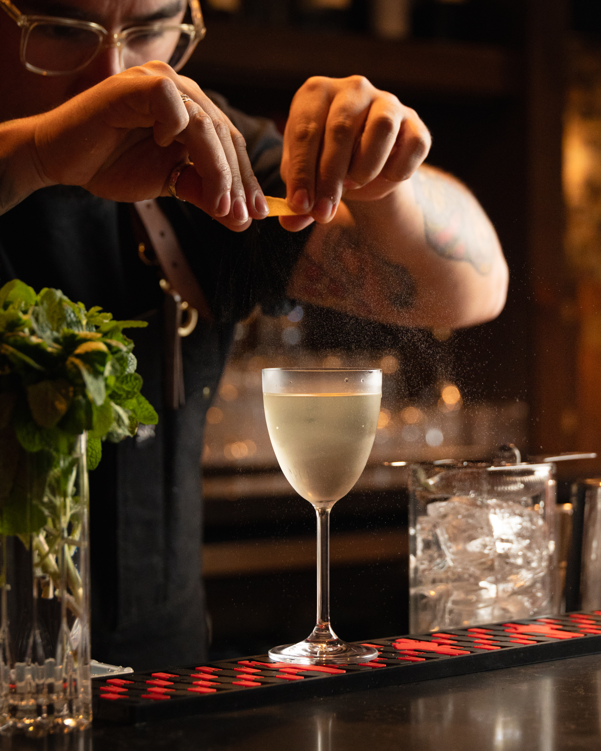 Bartender expressing citrus peel over a pale cocktail at Terminal City Club